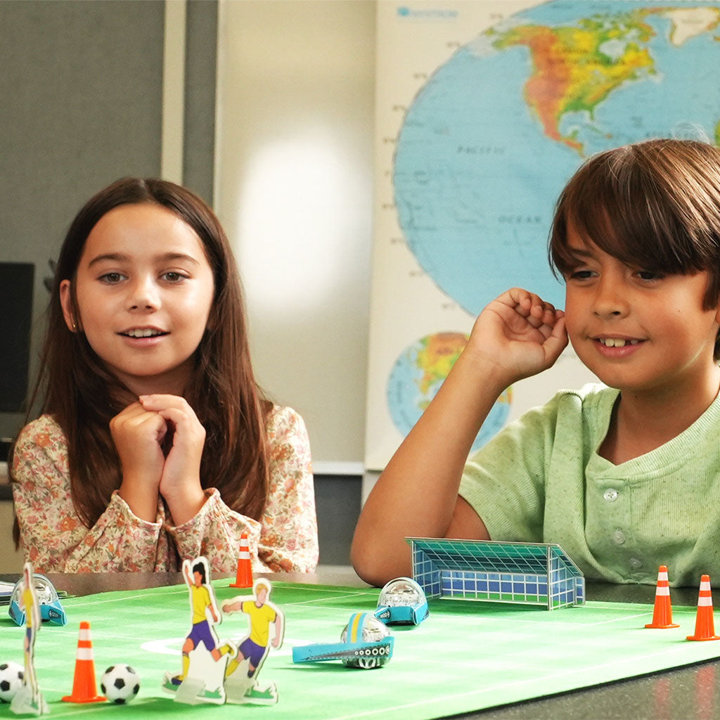 Children doing after-school STEM activities with Ozobot coding robots and Soccer Challenge Mat